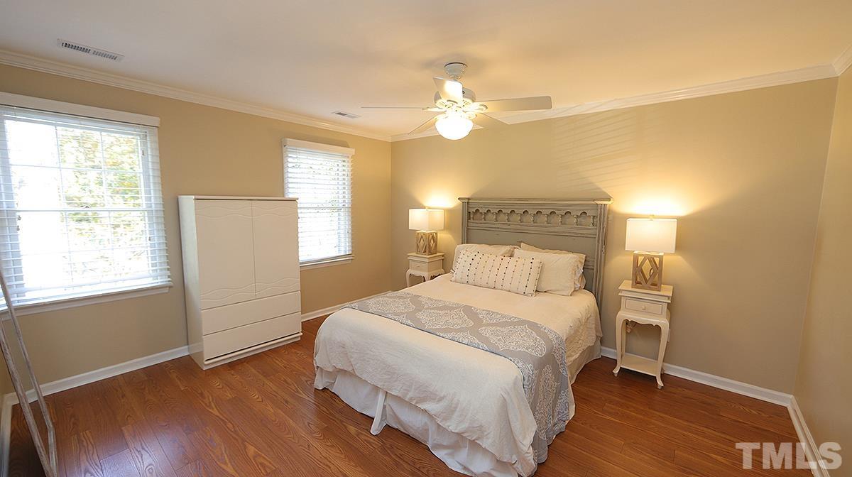 1104 Sapling Place Raleigh, NC 27615 - Photo 9 of 19 a bedroom with a bed and wooden floor