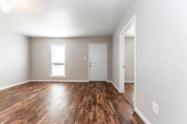 a view of a room with wooden floor and window