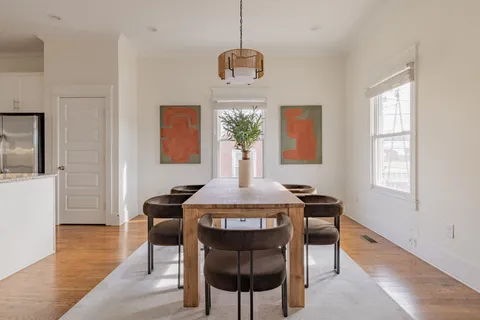 a dining room with furniture a chandelier and wooden floor