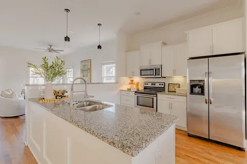 a kitchen with granite countertop a sink a counter top space stainless steel appliances and cabinets