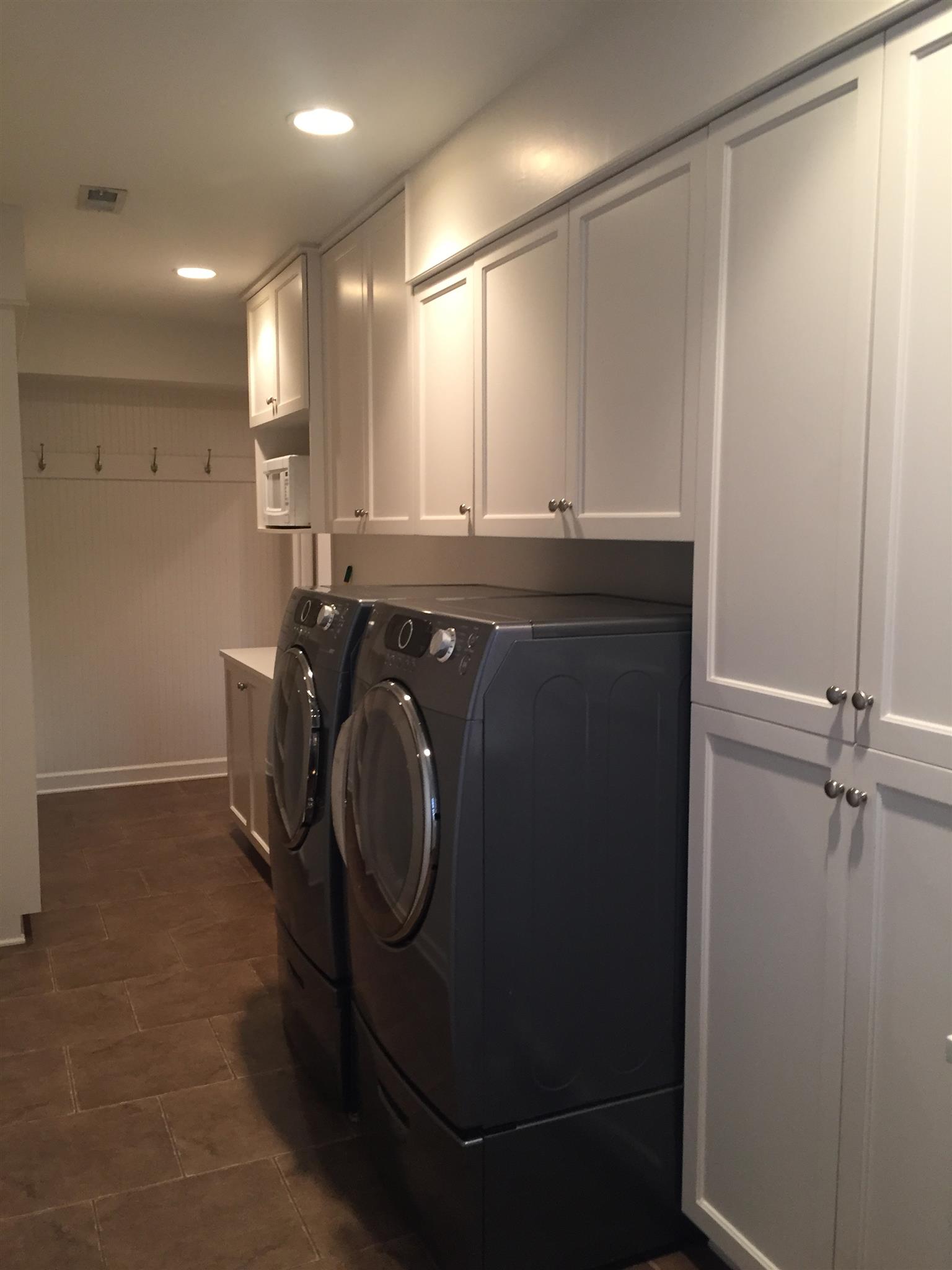 9366 Hester Beasley Road Nashville, TN 37221 - Photo 25 of 29 The Laundry Room is Very Spacious with Tons of Custom Cabinetry, Tile Floors, Shelving, a Counter, and a Sink. The Washer and Dryer Stay!