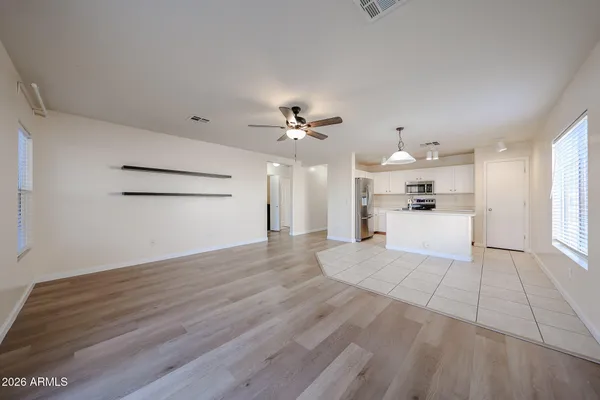 a view of a big room with wooden floor and windows