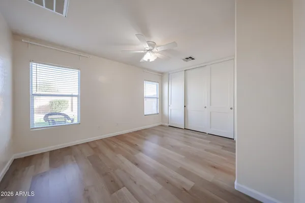 a view of an empty room with a window and wooden floor