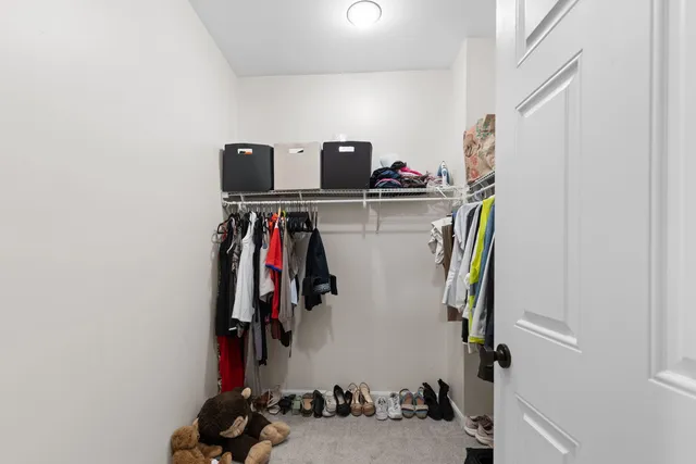 a view of walk in closet with clothes and shoes