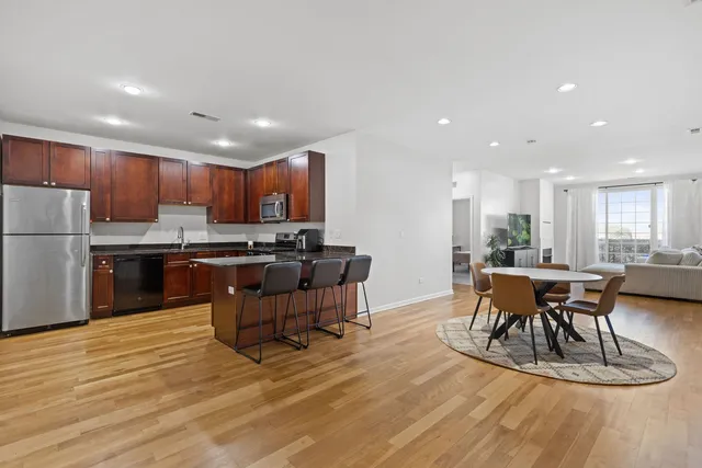 an open kitchen with kitchen island wooden cabinets and stainless steel appliances