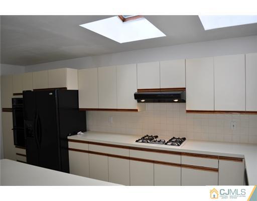 1 Agate Road East Brunswick, NJ 08816 - Photo 12 of 25 a kitchen with granite countertop a refrigerator and a stove