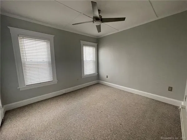 an empty room with a window and a fan