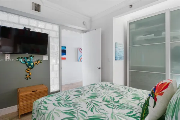 a bedroom with a bed and a flat screen tv