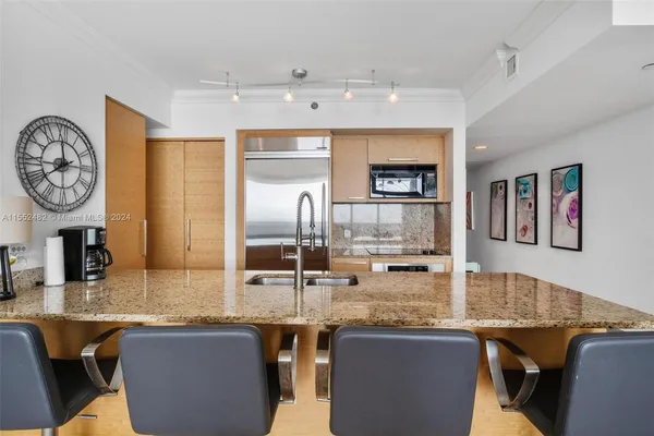 a kitchen with granite countertop a table and chairs in it