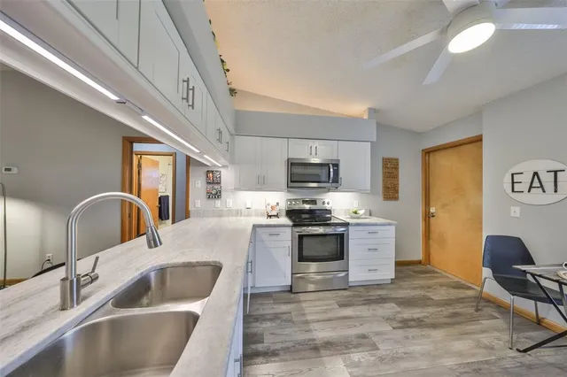 a kitchen with stainless steel appliances granite countertop a sink stove top oven and refrigerator