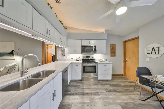 a kitchen with stainless steel appliances granite countertop a sink and cabinets