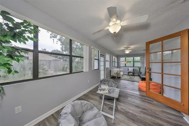 a living room with furniture a large window and wooden floor