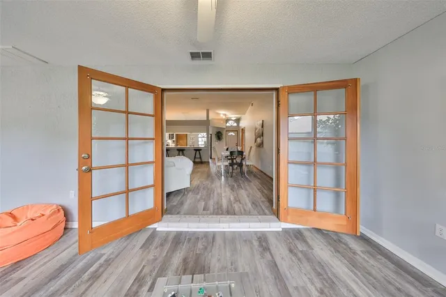 an empty room with wooden floor closet and windows
