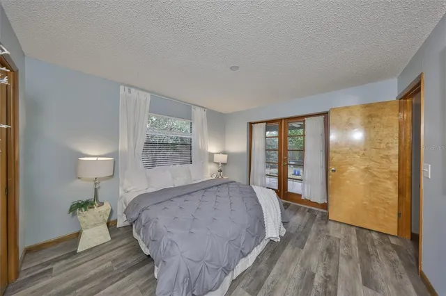a bedroom with a bed and wooden floor