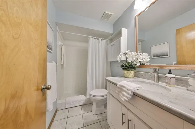 a bathroom with a granite countertop sink a toilet and a mirror