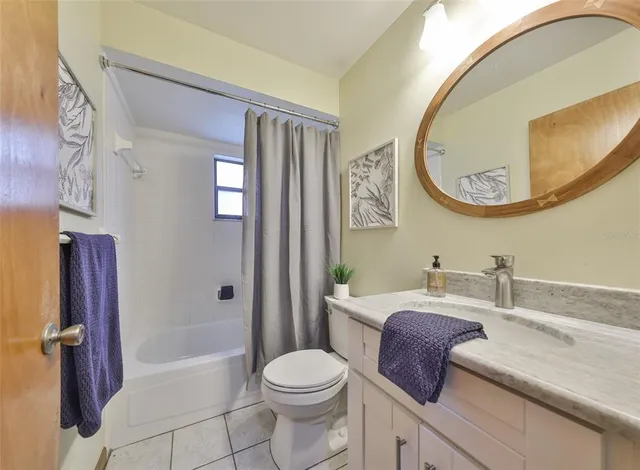 a bathroom with a bathtub sink mirror vanity and toilet