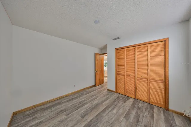 an empty room with wooden floor and sliding door