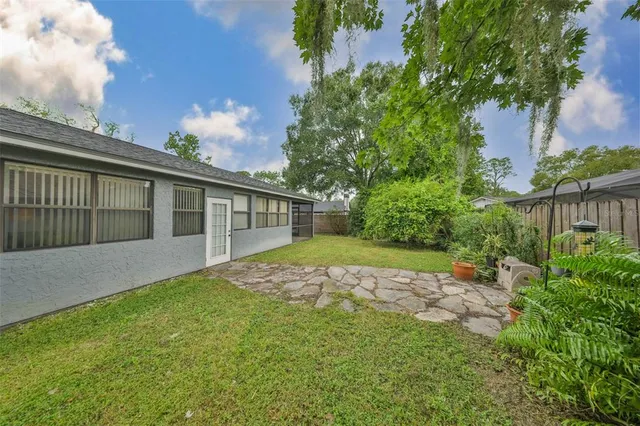 a view of backyard of house with green space