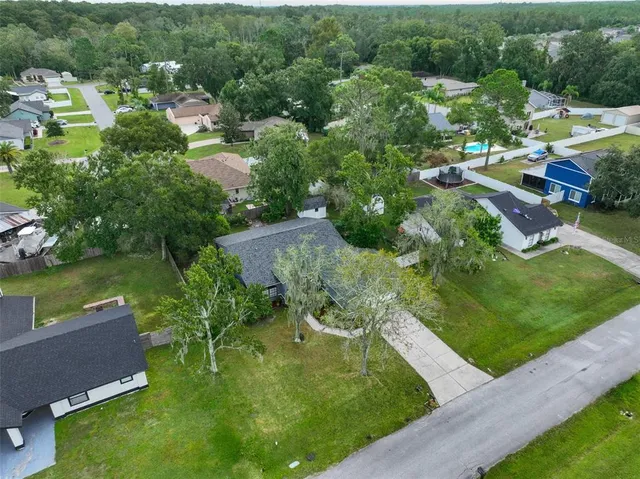 an aerial view of residential houses with outdoor space and lake view