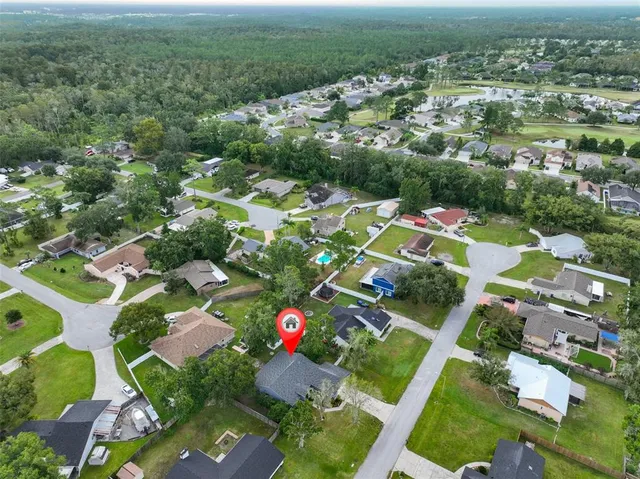 an aerial view of residential houses with outdoor space and parking