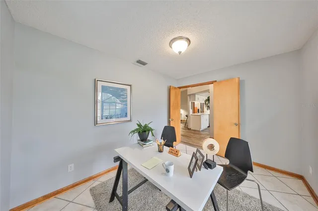 a view of a workspace with furniture and a window