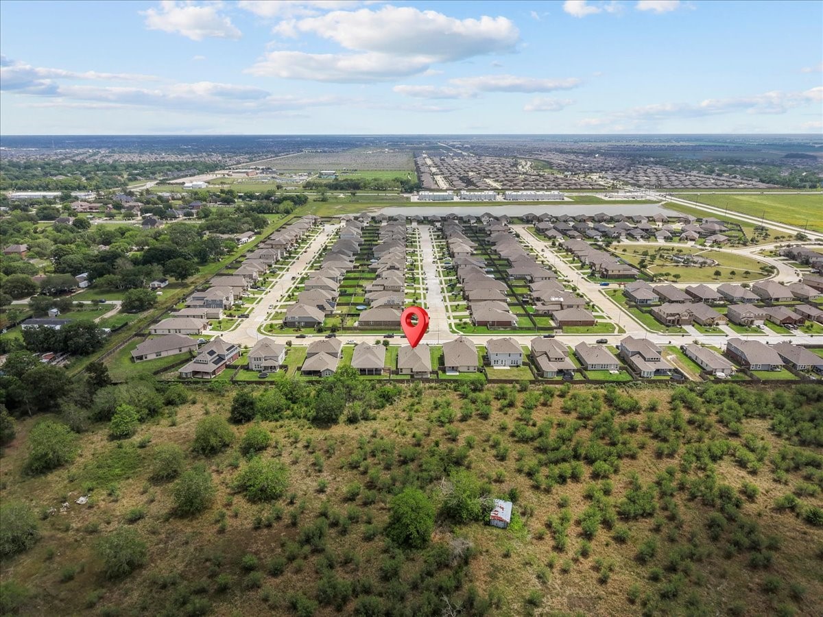 2320 Rosemary Street Rosenberg, TX 77469 - Photo 7 of 40 This aerial photo showcases a suburban neighborhood with neatly arranged houses and well-maintained lawns, surrounded by open green spaces. The highlighted property is centrally located within a peaceful residential area, offering a blend of community living and natural surroundings.