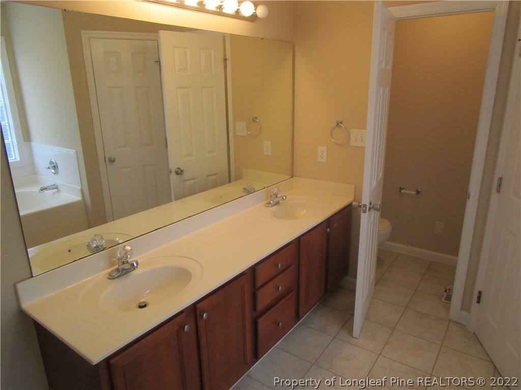 4328 Rocinta Court Hope Mills, NC 28348 - Photo 18 of 39 a bathroom with a sink a mirror and a bathtub