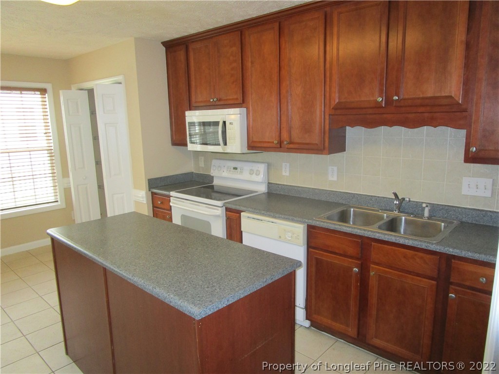 4328 Rocinta Court Hope Mills, NC 28348 - Photo 3 of 39 a kitchen with stainless steel appliances granite countertop a sink stove and cabinets