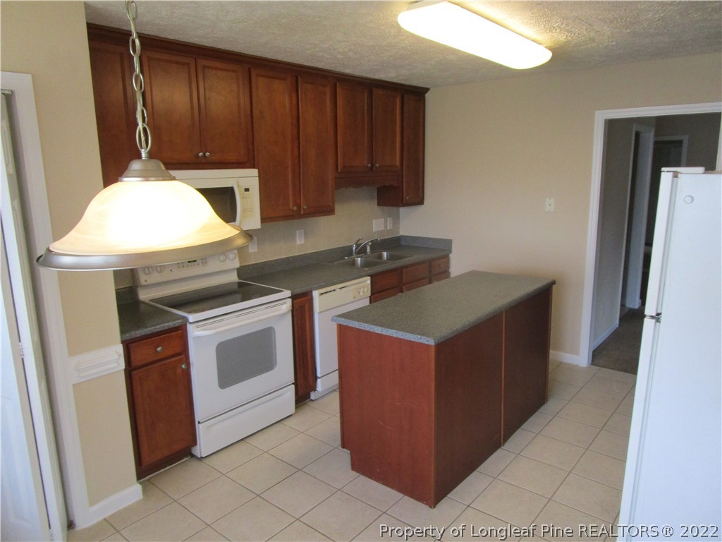4328 Rocinta Court Hope Mills, NC 28348 - Photo 4 of 39 a kitchen with stainless steel appliances granite countertop a stove a refrigerator and a microwave