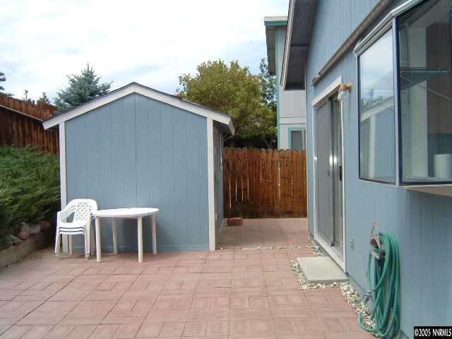 6052 Walnut Creek Road Reno, NV 89523 - Photo 5 of 5 a backyard of a house with chairs and wooden fence