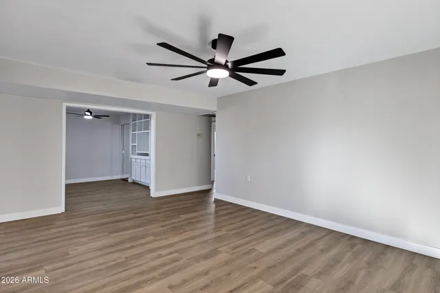 an empty room with cabinet and ceiling fan