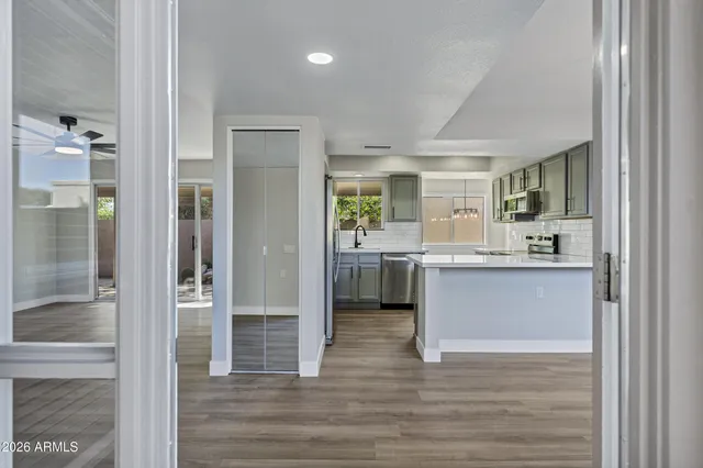 a living room with stainless steel appliances kitchen island granite countertop furniture a rug and a window