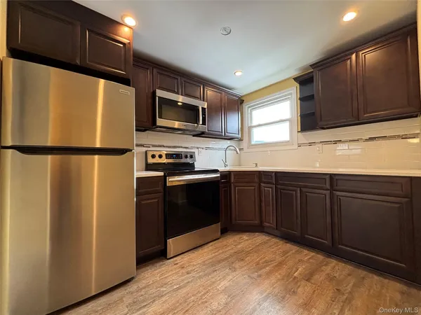 a kitchen with stainless steel appliances granite countertop a refrigerator stove a sink dishwasher and microwave