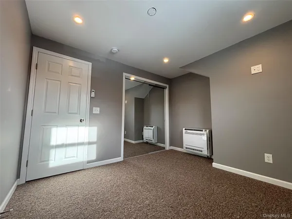 an empty room with windows and closet