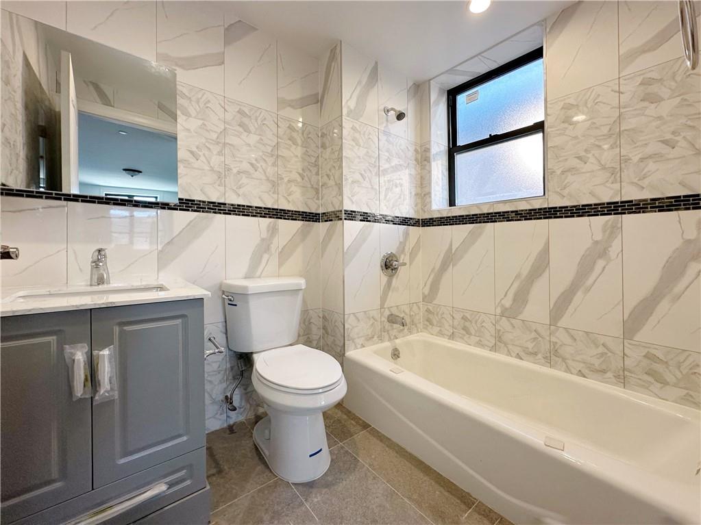 1307 84th Street, Unit 2B Brooklyn, NY 11228 - Photo 15 of 18 a bathroom with a sink a toilet and a bathtub
