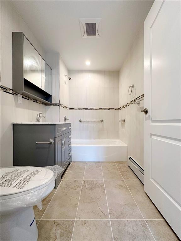 1307 84th Street, Unit 2B Brooklyn, NY 11228 - Photo 16 of 18 a bathroom with a tub a double vanity sink and mirror