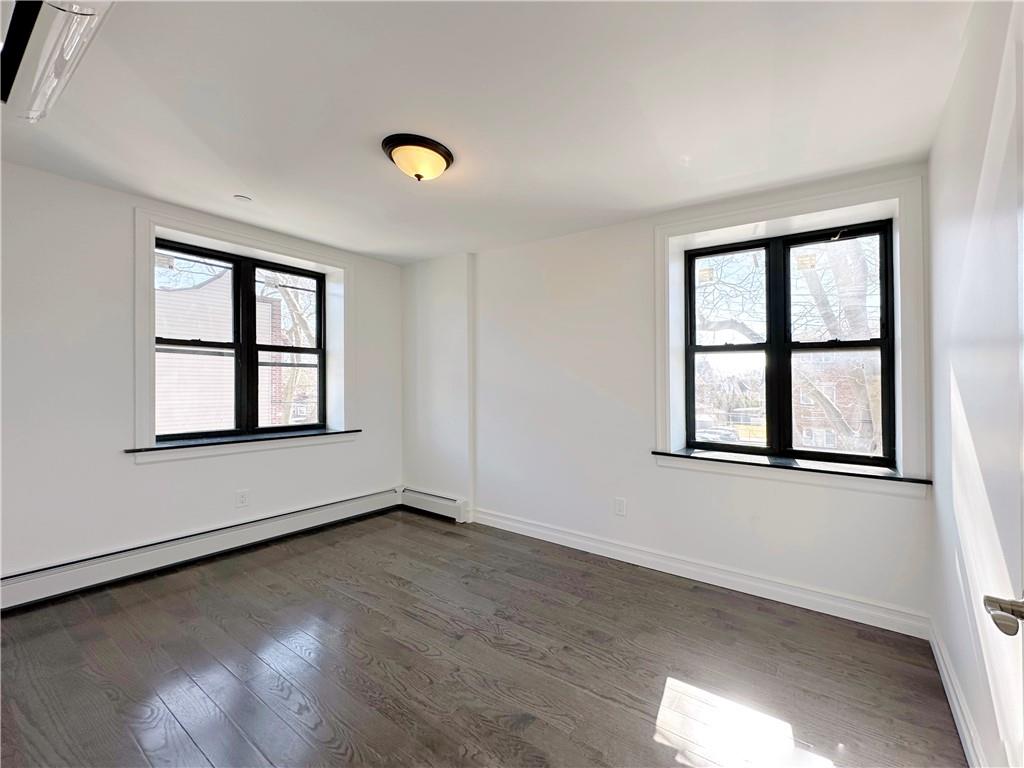 1307 84th Street, Unit 2B Brooklyn, NY 11228 - Photo 4 of 18 an empty room with wooden floor and windows