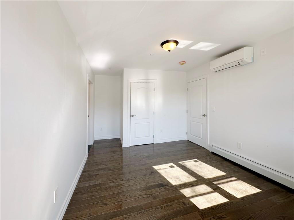 1307 84th Street, Unit 2B Brooklyn, NY 11228 - Photo 10 of 18 an empty room with wooden floor and windows