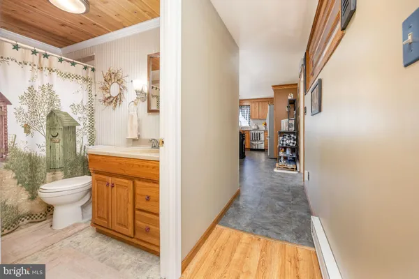 a bathroom with a granite countertop sink a toilet and shower