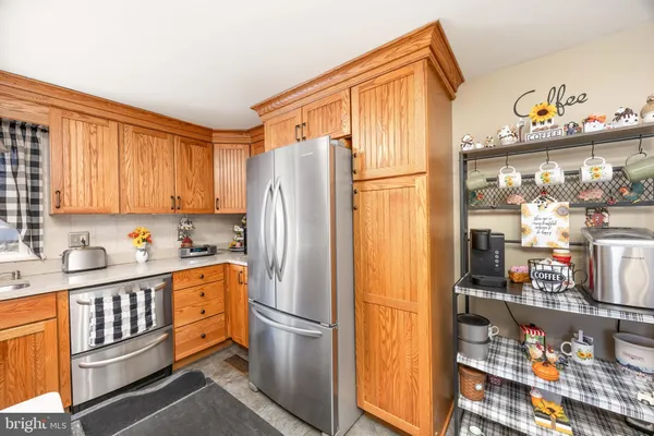 a kitchen with stainless steel appliances granite countertop a refrigerator and a stove top oven