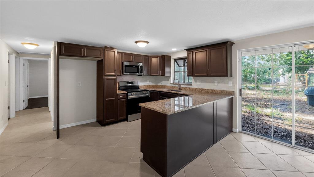 17220 Estes Road Lutz, FL 33548 - Photo 4 of 25 a kitchen with stainless steel appliances granite countertop a refrigerator and a sink