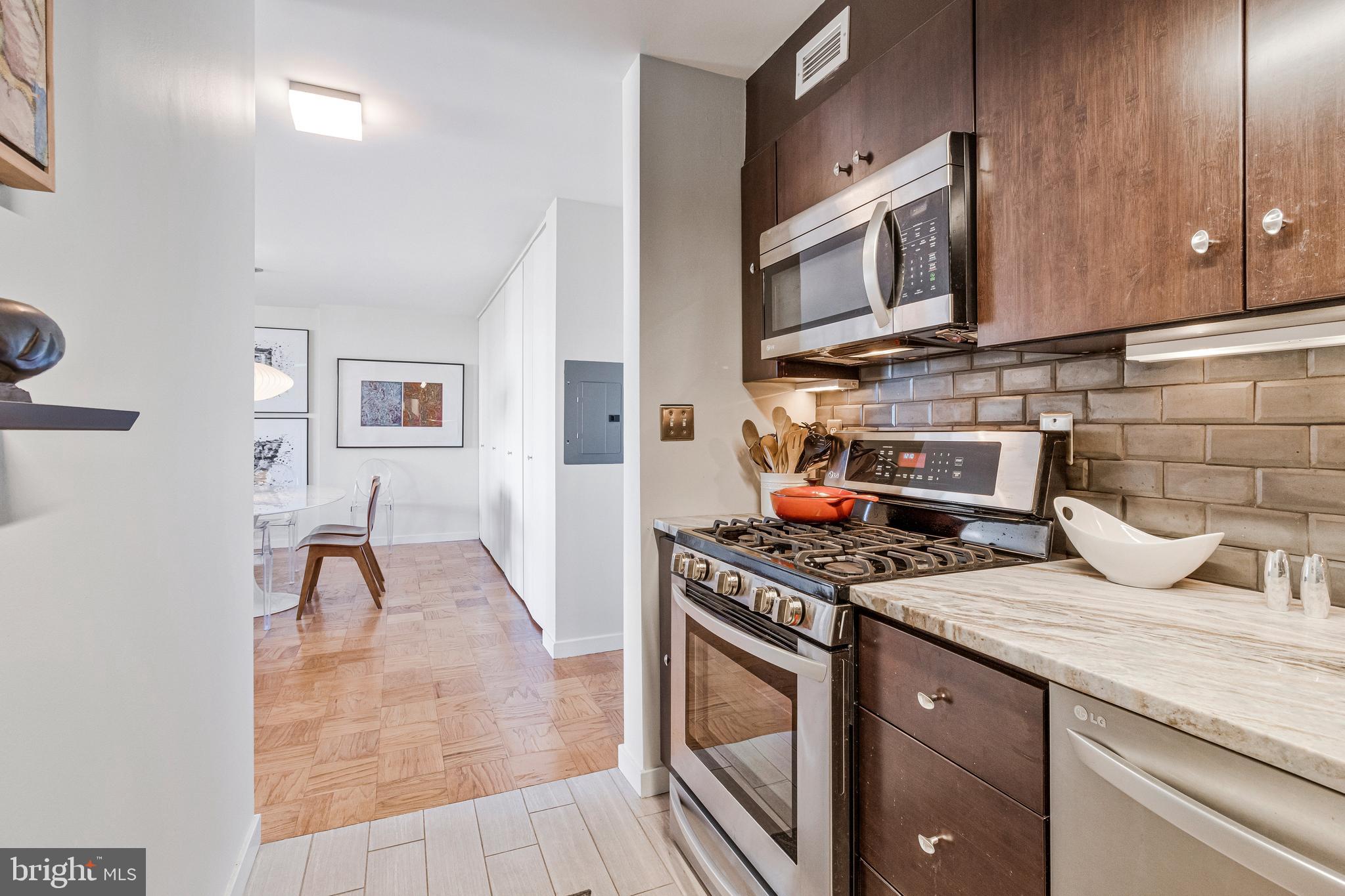 1245 4th Street Southwest, Unit E501 Washington, DC 20024 - Photo 18 of 40 a kitchen with stainless steel appliances granite countertop a stove and a microwave