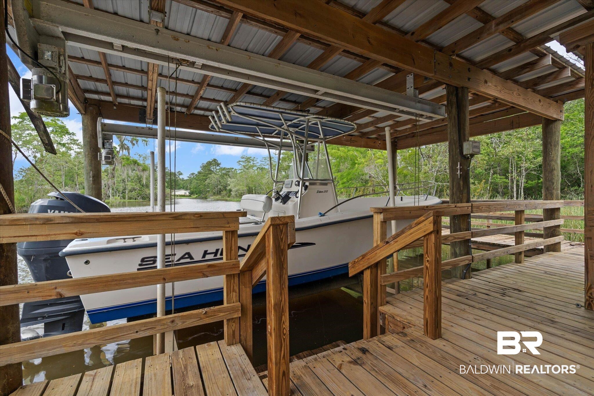 3500 Venetia Road Mobile, AL 36605 - Photo 43 of 56 Covered boat dock featuring a metal roof, wood-plank decking, and a boat lift