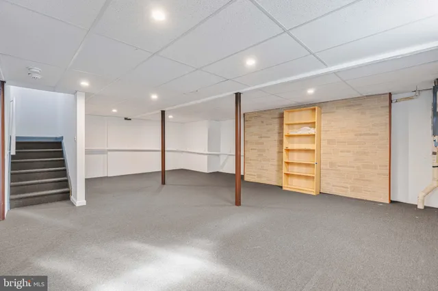 an empty room with ceiling fan and windows