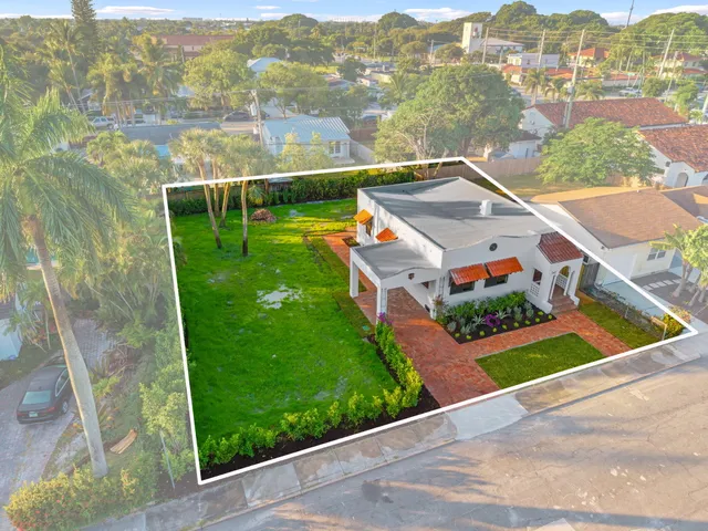 an aerial view of residential houses with outdoor space and city view