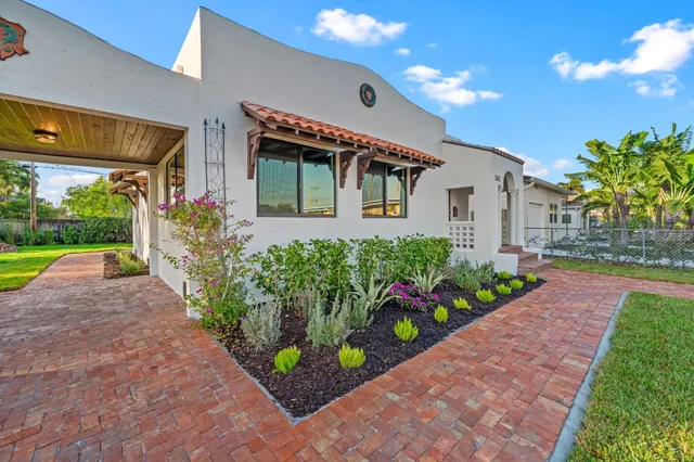 a front view of a house with a yard and flowers