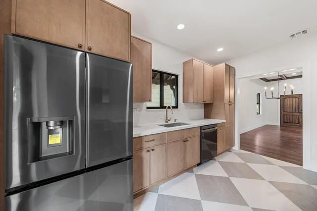 a kitchen with stainless steel appliances granite countertop a refrigerator and a sink