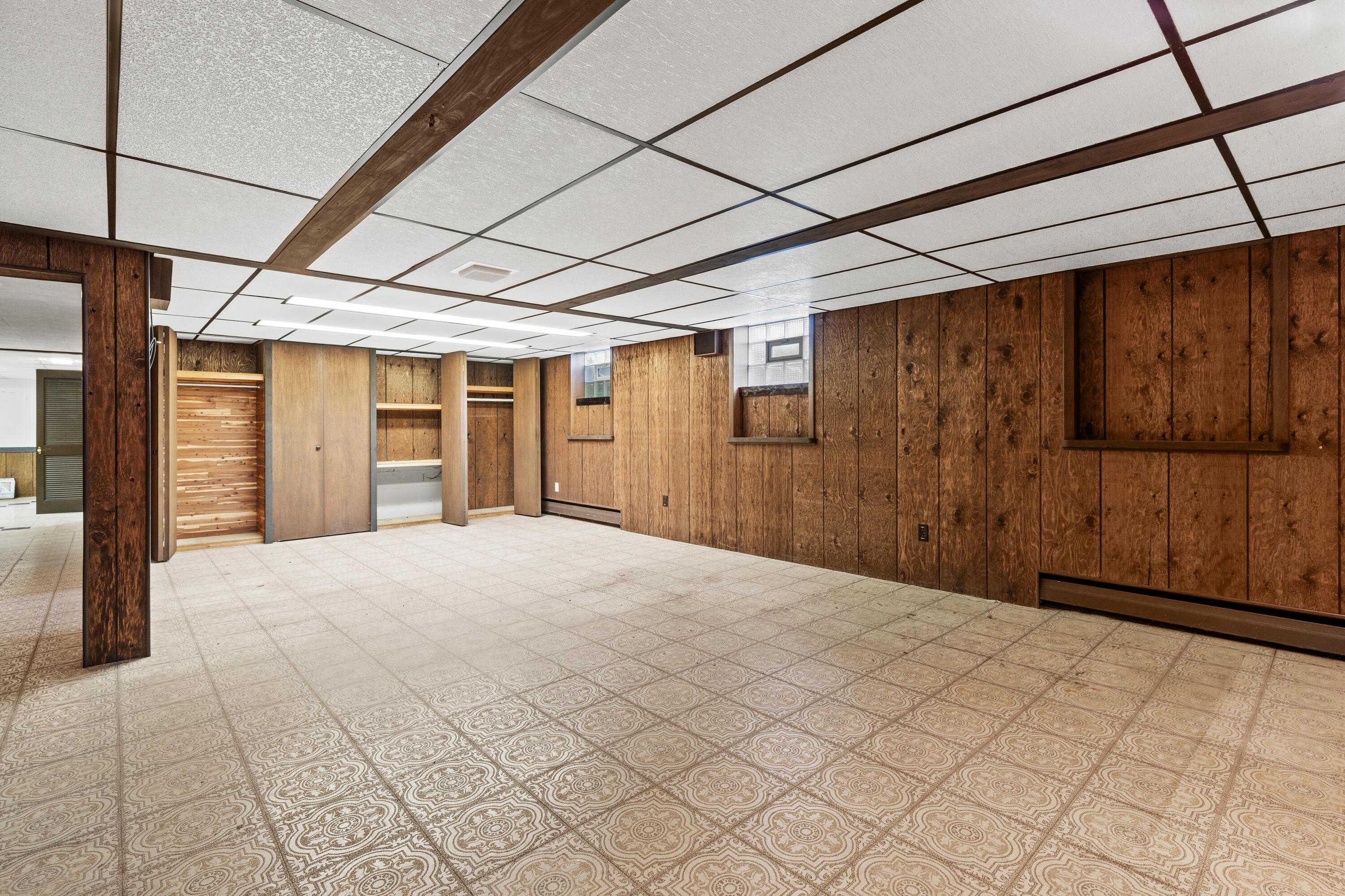 6982 Lee Road Westerville, OH 43081 - Photo 49 of 71 • Neutral vinyl flooring • Paneled walls • Acoustic ceiling tiles with fluorescent lighting • Can lighting • Woodburning, brick fireplace • Baseboard heat • (2) glass block windows • Built-in book shelves • Full wall of closets (cedar lined)