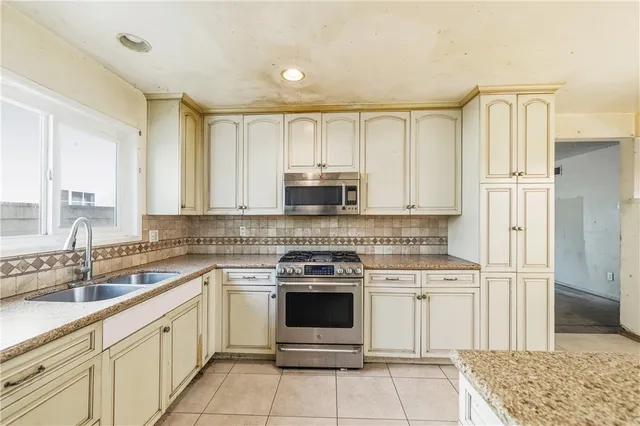 a kitchen with granite countertop white cabinets and stainless steel appliances