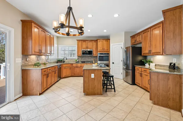 a kitchen with stainless steel appliances a sink a counter top space cabinets and a window
